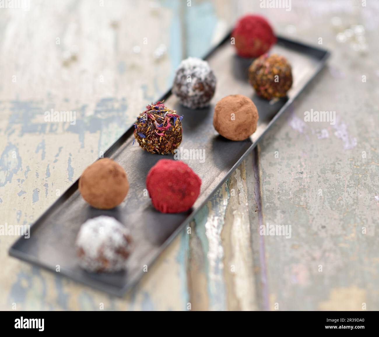 Chocolate date and walnut balls with cocoa, coconut, dried petals and