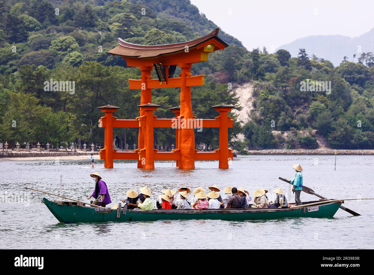 Miyajima, Japan, May 22, 2023 - Tourists look at the Grand Torii Gate from a boat in Miyajima. Visitors returned to Itsukushima-jinja Shrine a day after the leaders’ meeting G7 Hiroshima Summit ended on May 21. The Shinto shrine is well known for its iconic floating Itsukushima Jinja Otorii (Grand Torii Gate) and World Heritage Site. Stock Photo