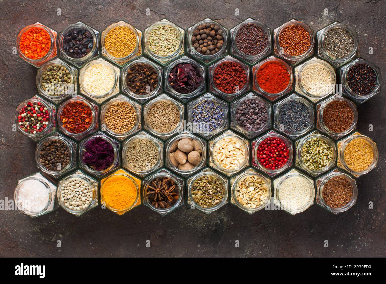 Different kinds of spices and herbs in glass on grey background Stock Photo