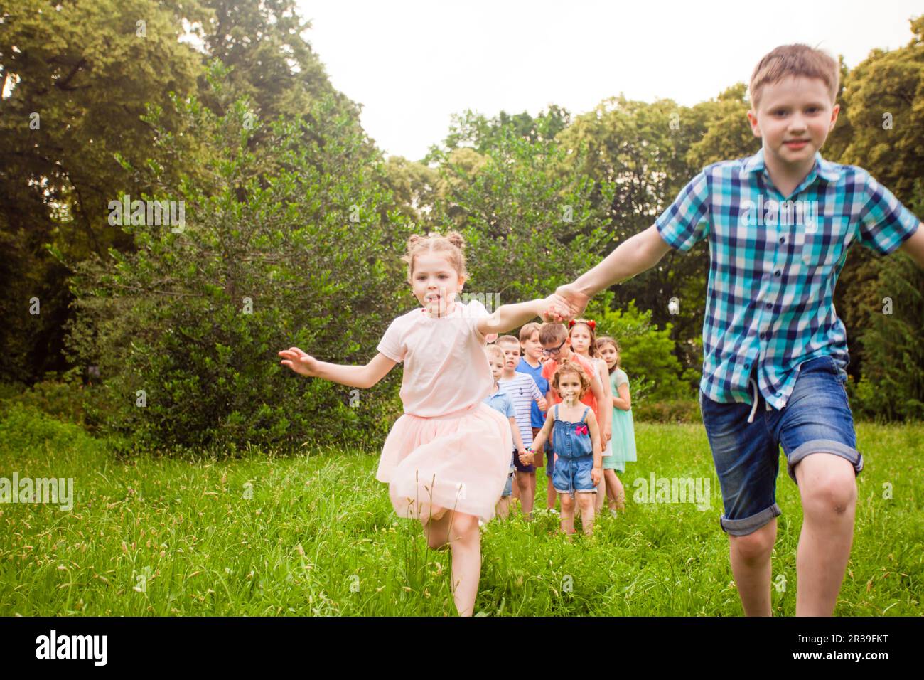 Happy kids playing outdoors game on birthday party Stock Photo