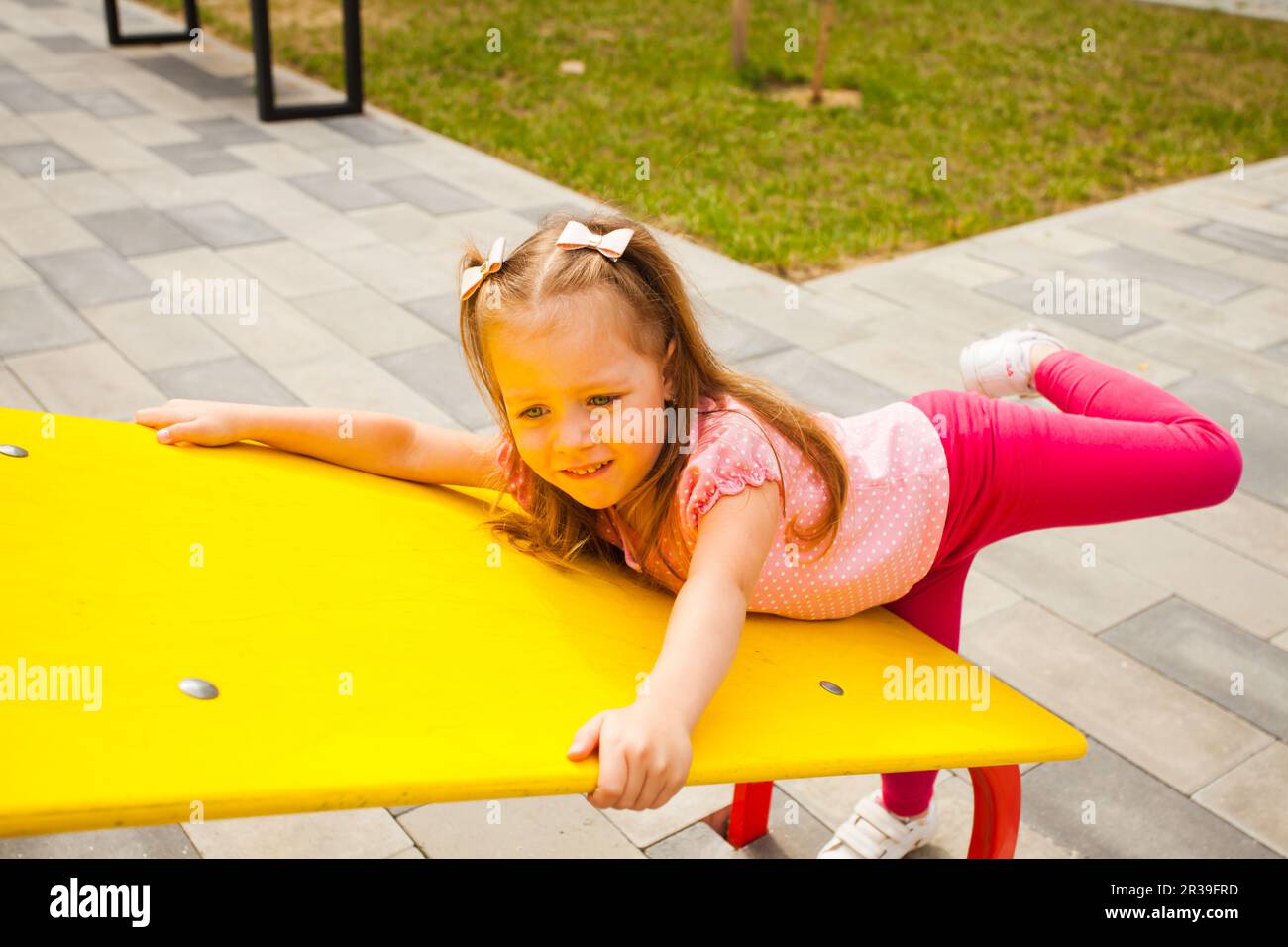 Cute little girl playing on the outdoors playground. Stock Photo