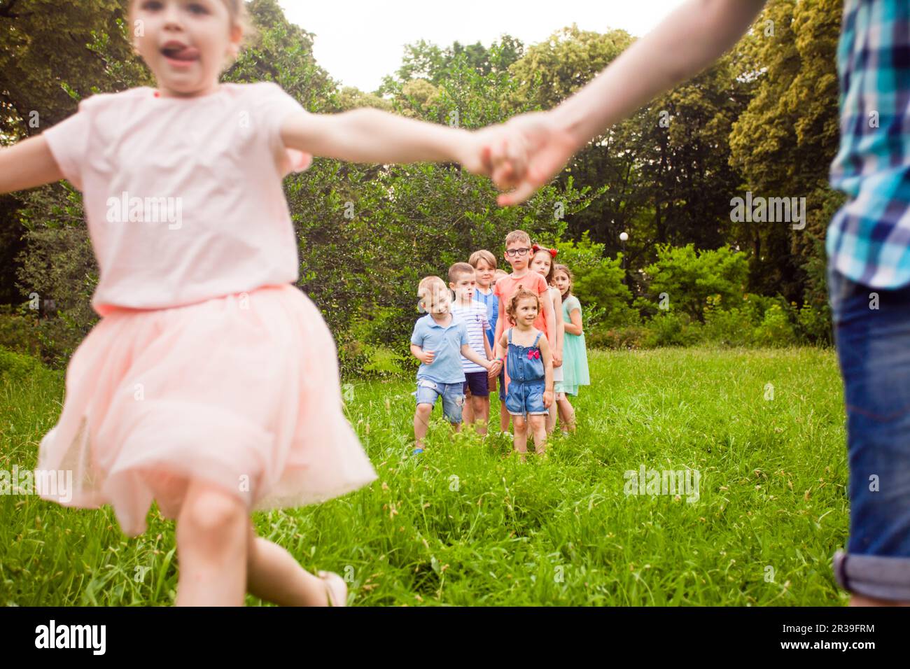 Happy friends playing outdoors game on birthday party in summer park Stock Photo