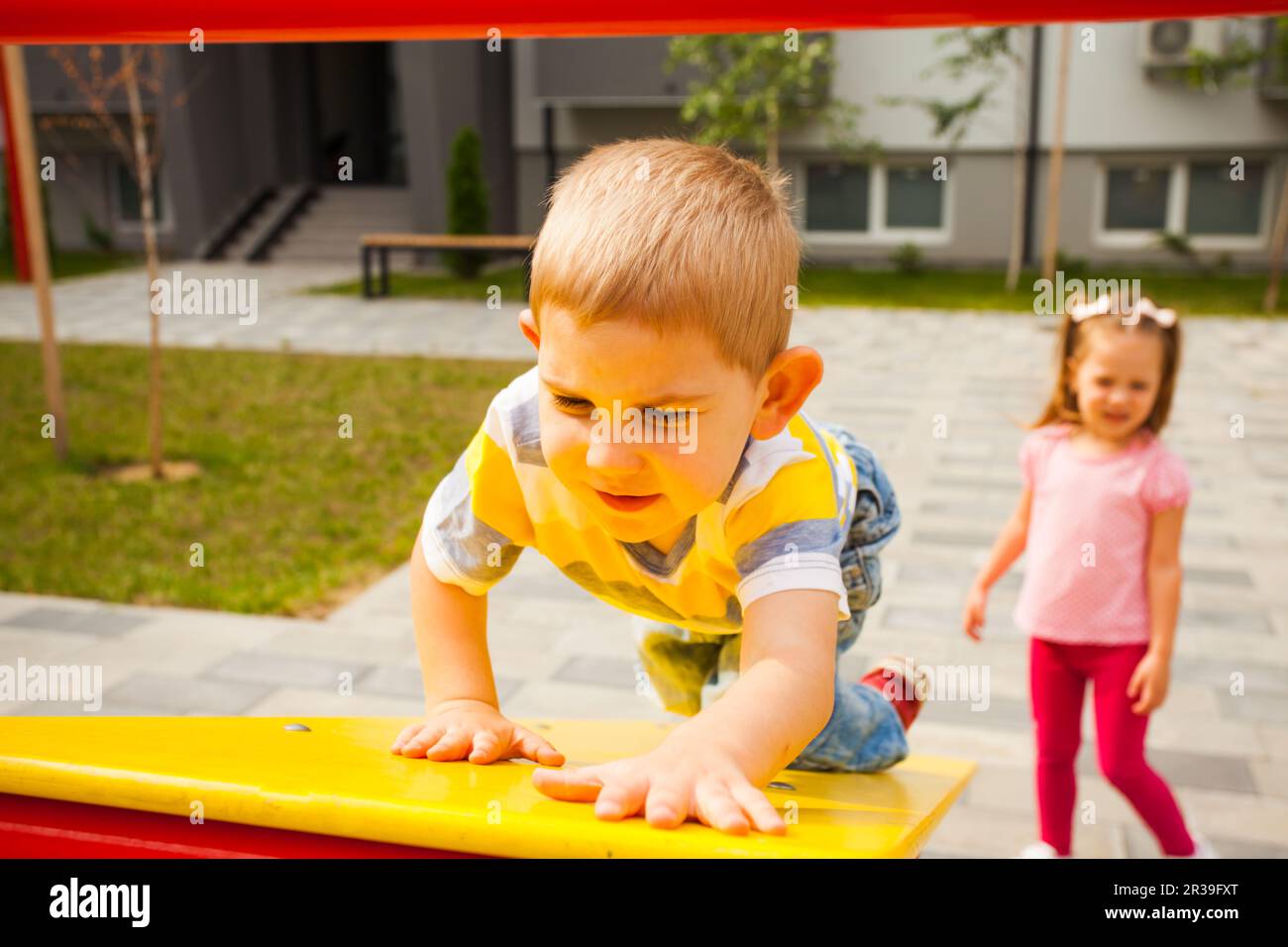Kids playing together at modern playground outdoors Stock Photo