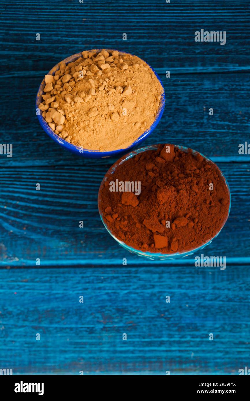 Natural cocoa substitute. Healthy eating concept. Organic carob and cacao powder in bowls. Stock Photo