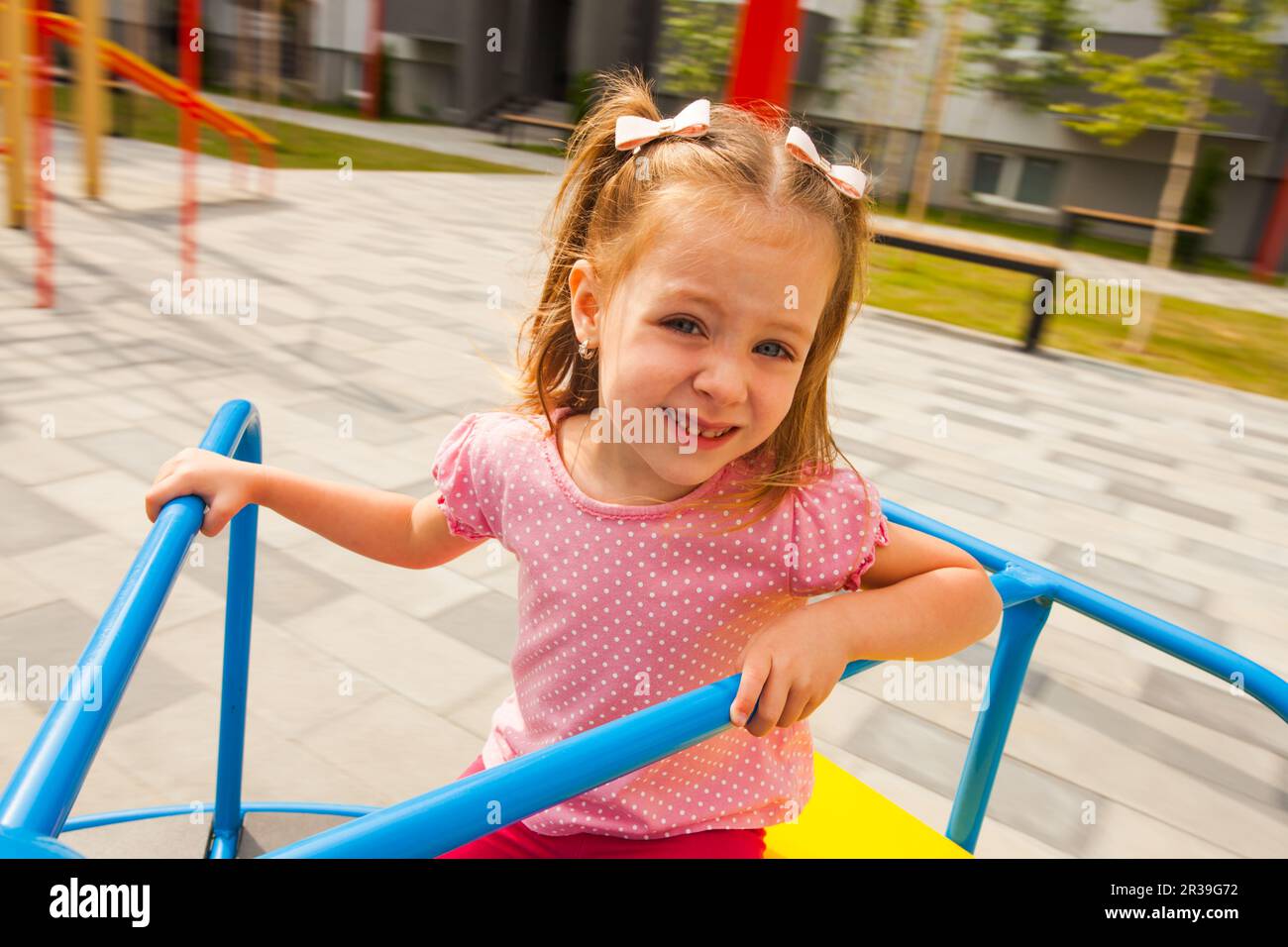 Little girl playing on the outdoors playground. Stock Photo