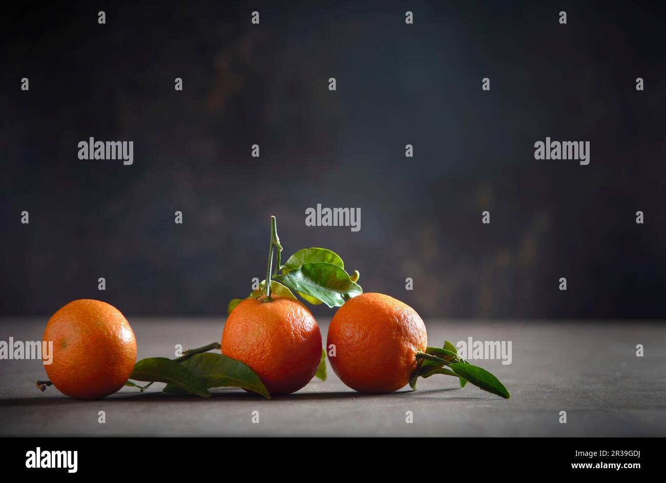 Three mandarin oranges with leaves Stock Photo