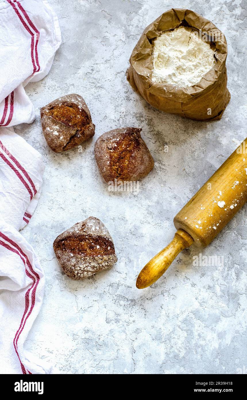 A close-up of a woman potter rolls a brown clay rolling pin on a special  fabric on a wooden table to make a plate and New Year's toys, on the table  li