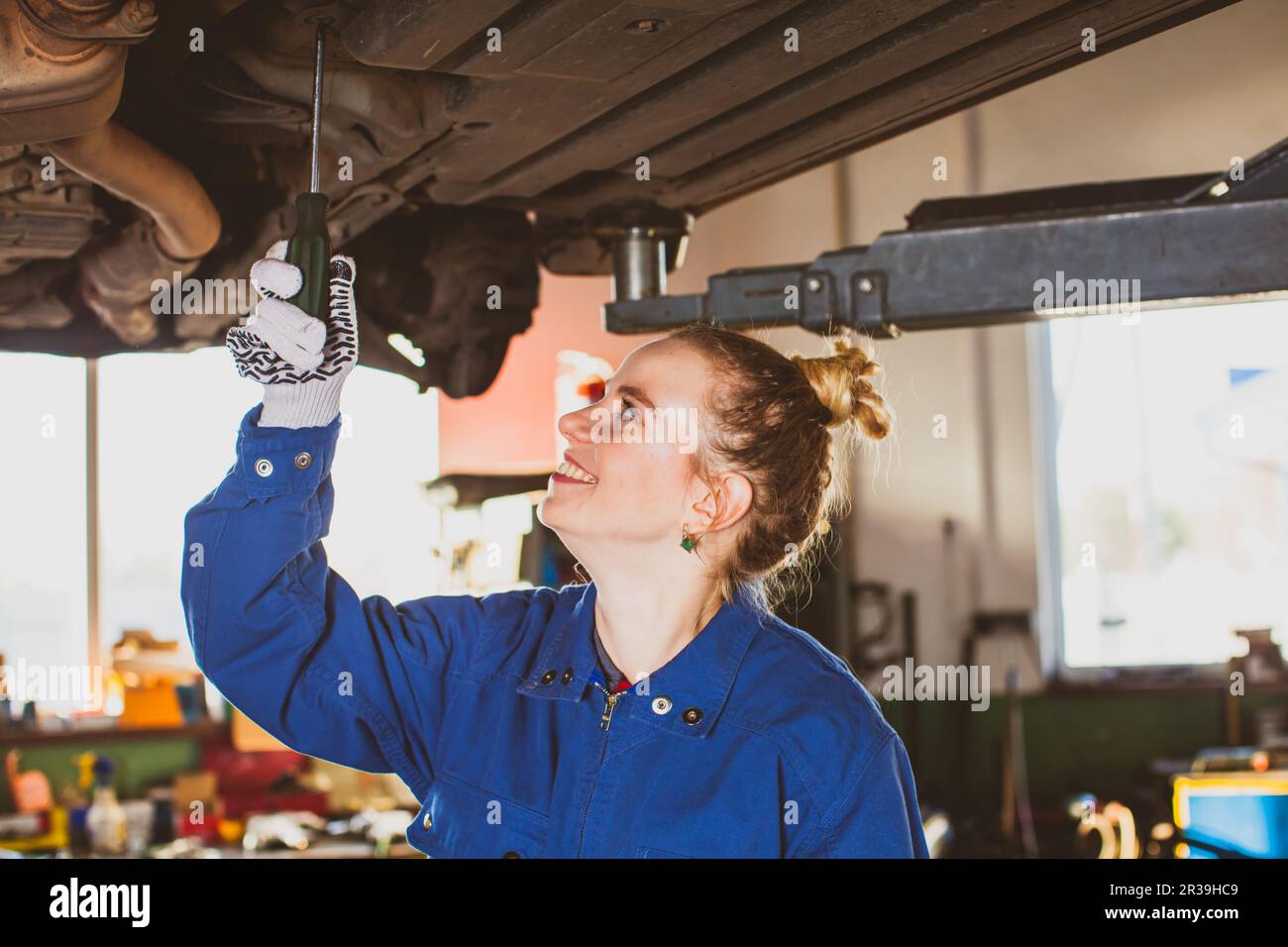 Female mechanic repairing a car in garage Stock Photo