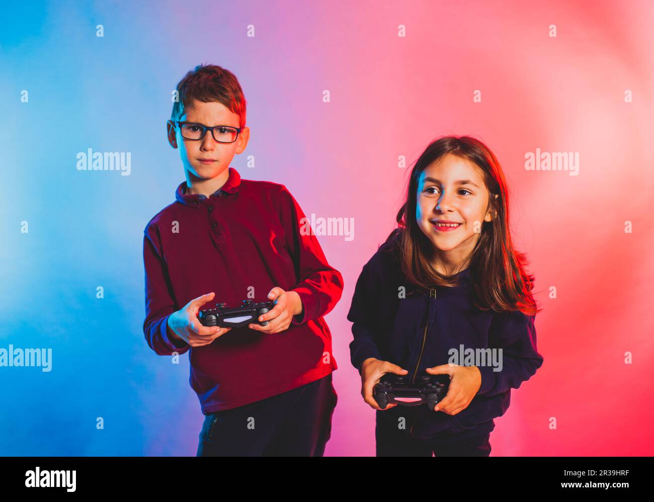 Emotional girl and boy playing virtual game Stock Photo