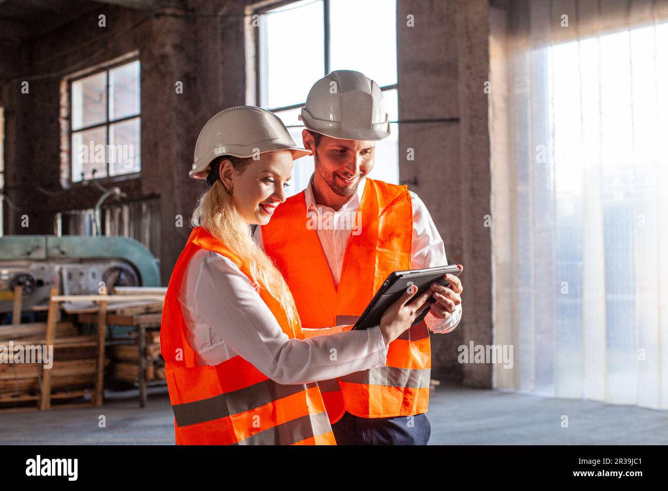 Young professional people with helmets working in quality control in warehouse Stock Photo