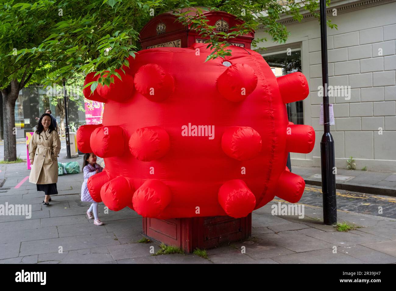 London, UK.  23 Mary 2023. Passers by interact with British artist Steve Messam’s inflatable artwork, Box K2, shrouding a telephone box which has been unveiled in Clerkenwell as part of Clerkenwell Design Week which runs to 25 May.    Credit: Stephen Chung / Alamy Live News Stock Photo