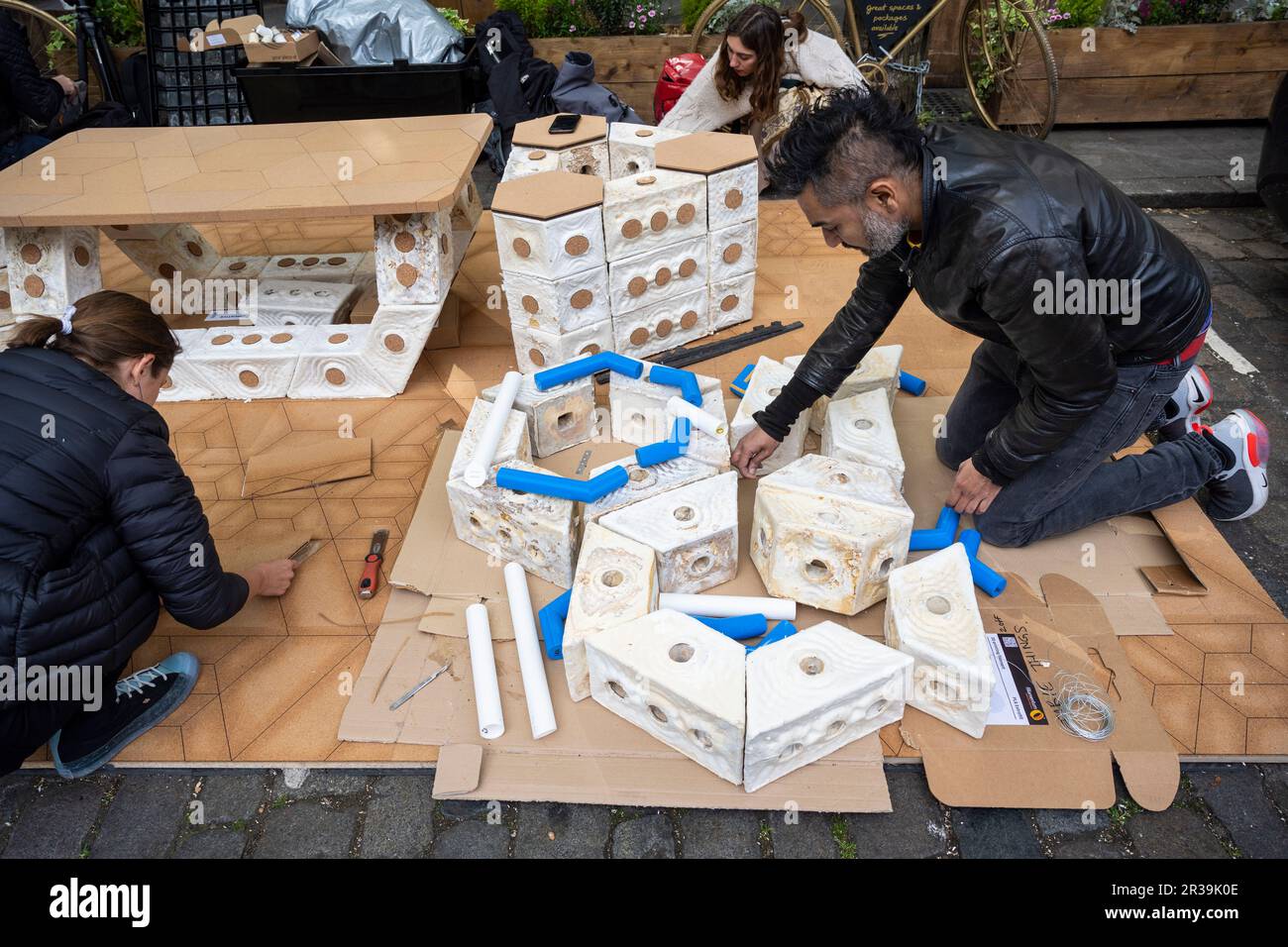 London, UK.  23 Mary 2023. Staff members assemble 'Symbiocene Living' by PLP Architecture, made from mycelium, in Clerkenwell as part of Clerkenwell Design Week which runs to 25 May.    Credit: Stephen Chung / Alamy Live News Stock Photo