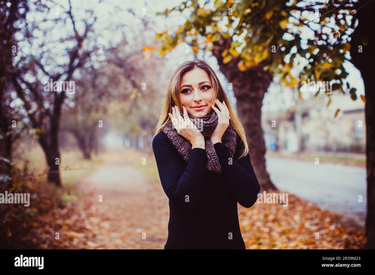 Pretty teenage girl with long hair. Beautiful young woman walking outdoors in autumn. Stock Photo