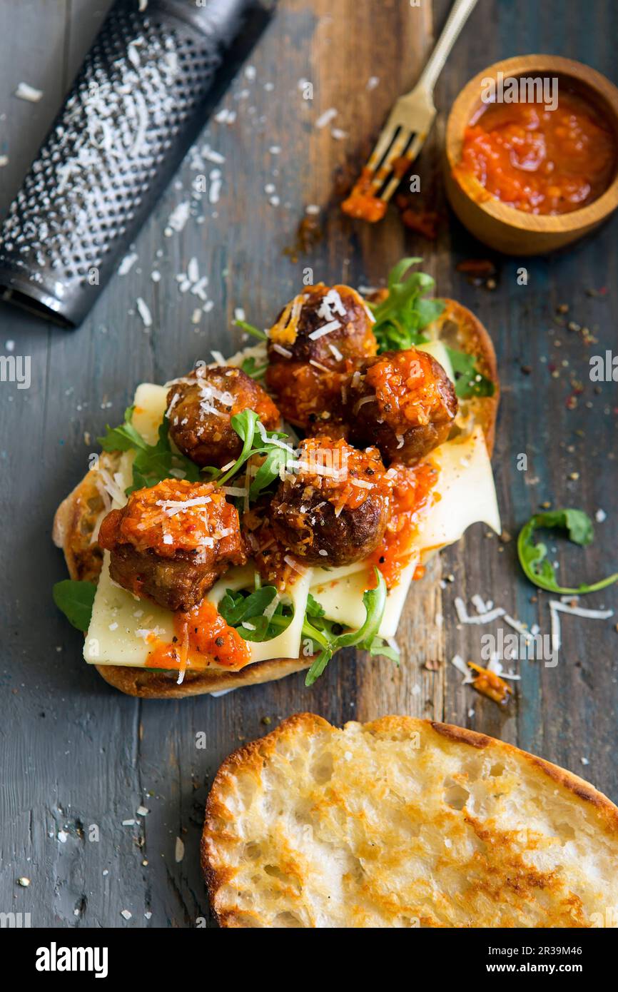 Vegetarian meat substitute meatballs with swiss cheese and a tomato