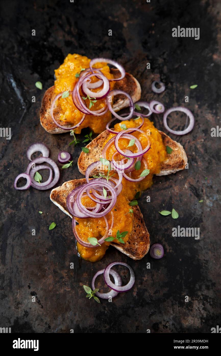 Yellow pepper spread on toast with red onions Stock Photo Alamy