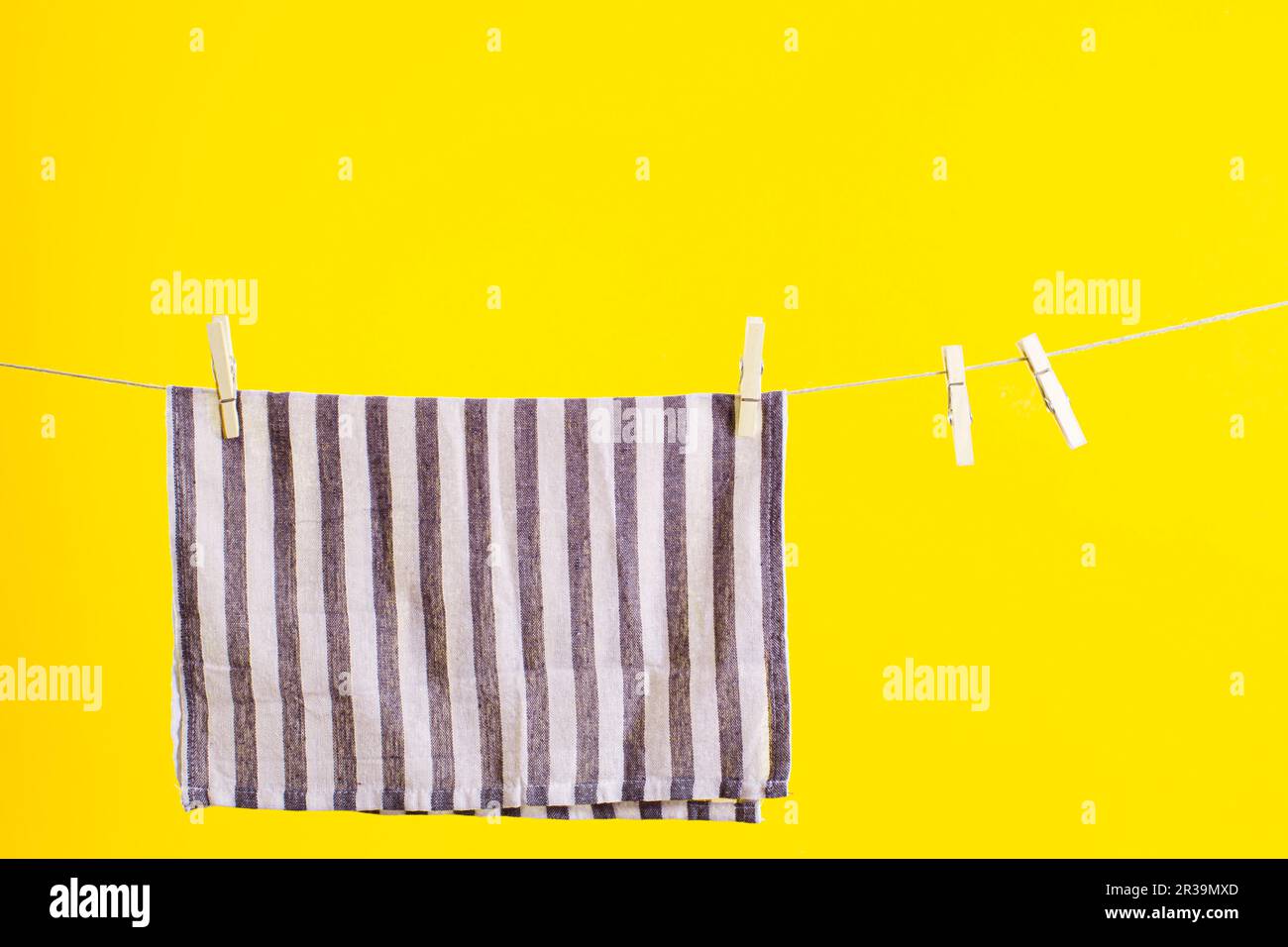 Kitchen towel after washing over yellow background. Mock up for design. Cleaning services Stock Photo