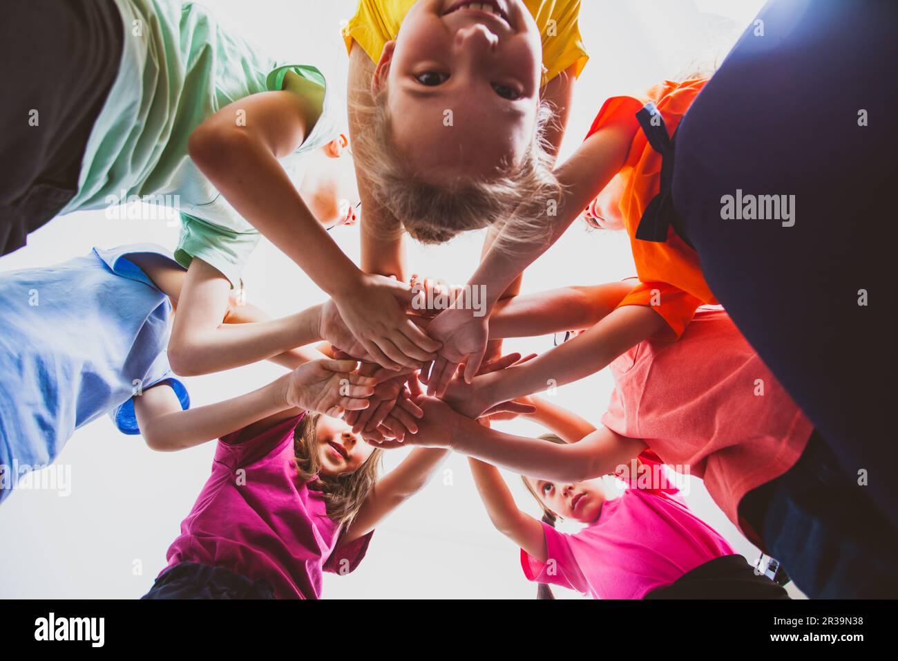 Happy children putting their hands together outdoors. Summer outdoors games and leisure. Stock Photo