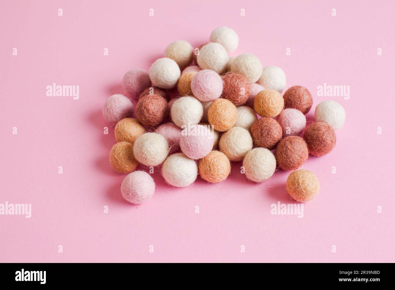 Pale of soft wool balls on pink background Stock Photo