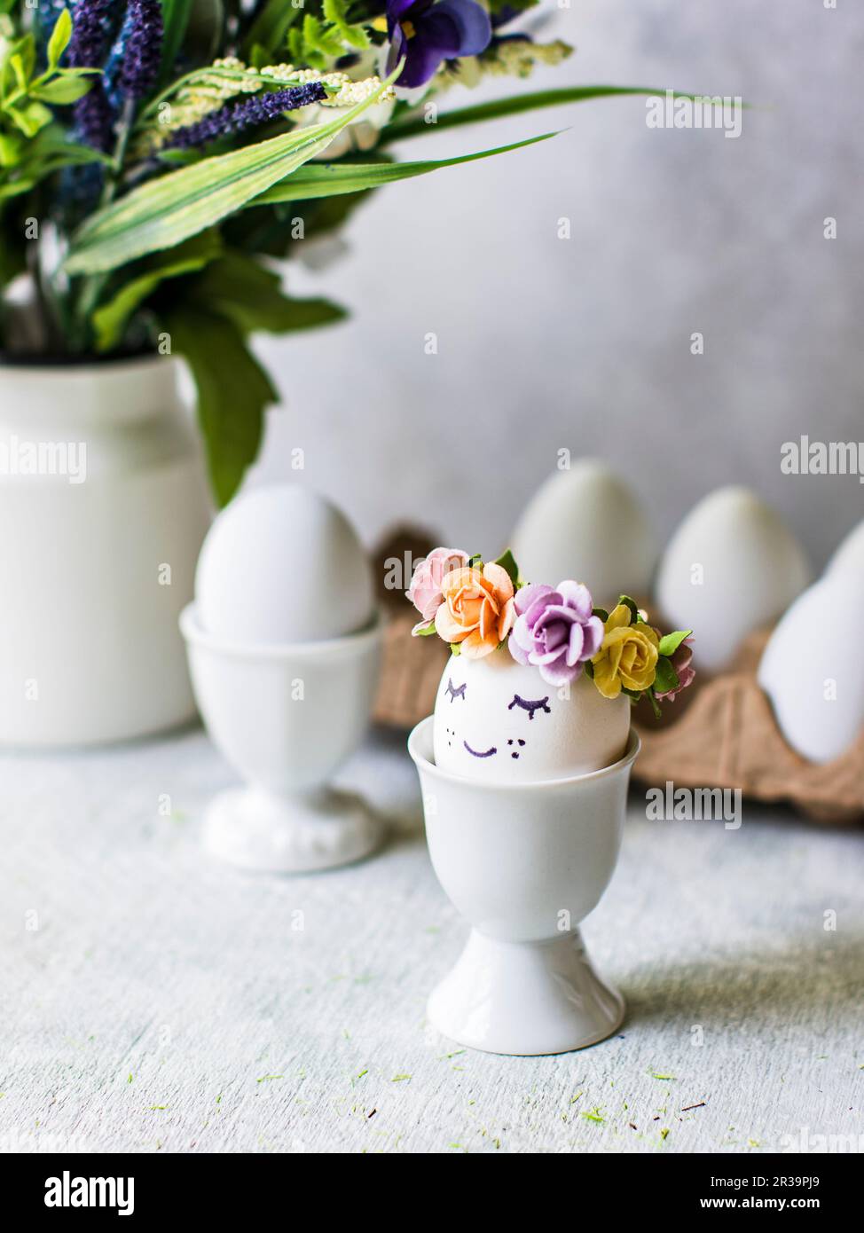 Easter eggs with flower decorations in eggcups Stock Photo