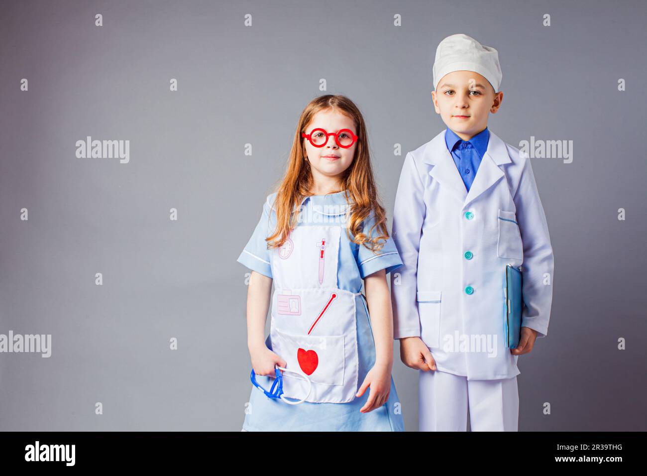 Cute boy and girl in medical uniform playing like doctors. Stock Photo