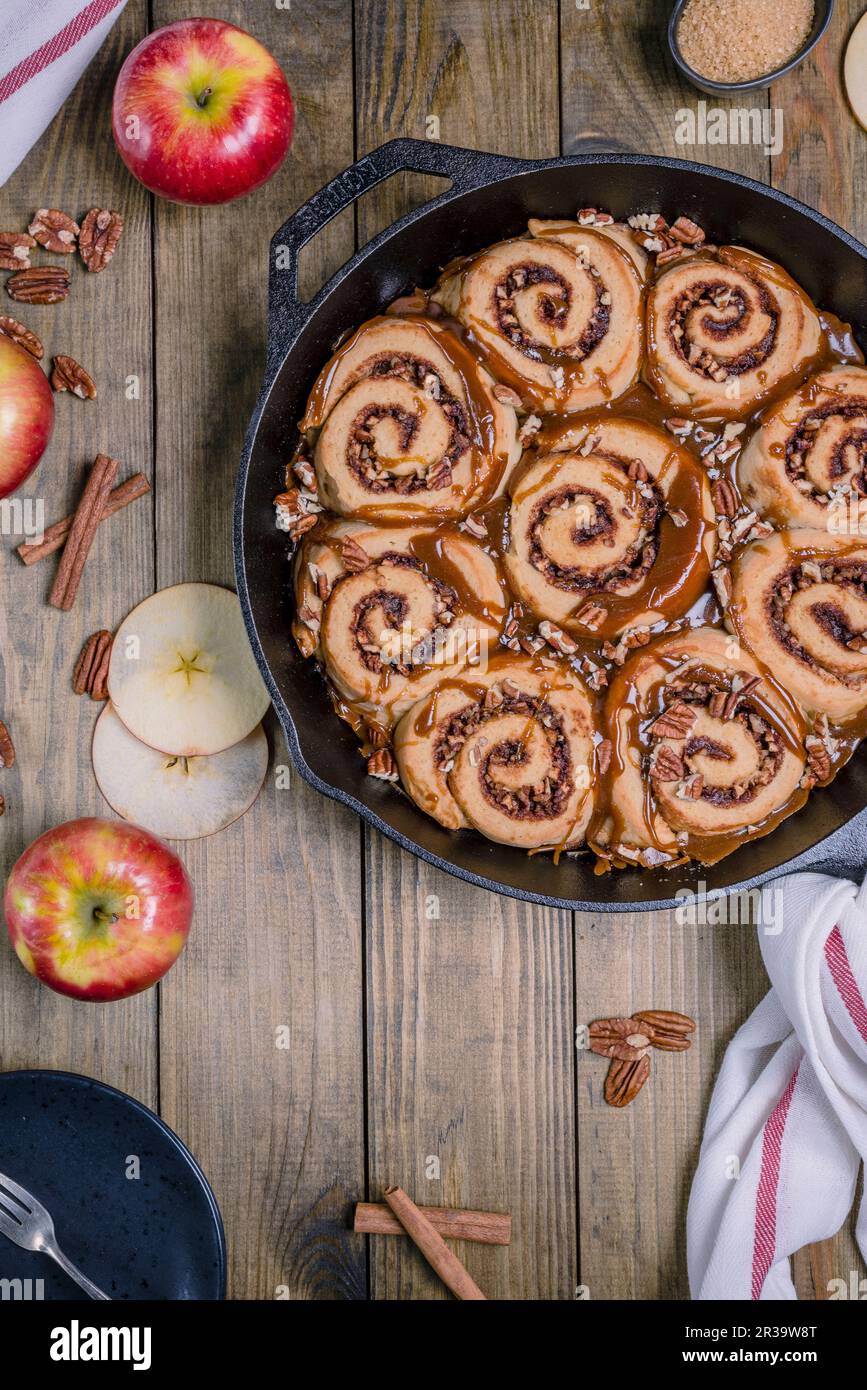 Apple pecan sticky buns with caramel sauce in a cast iron pan Stock