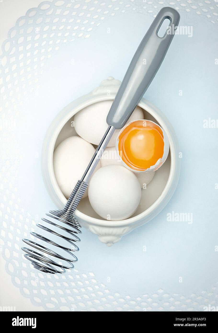 Eggs and a whisk Stock Photo