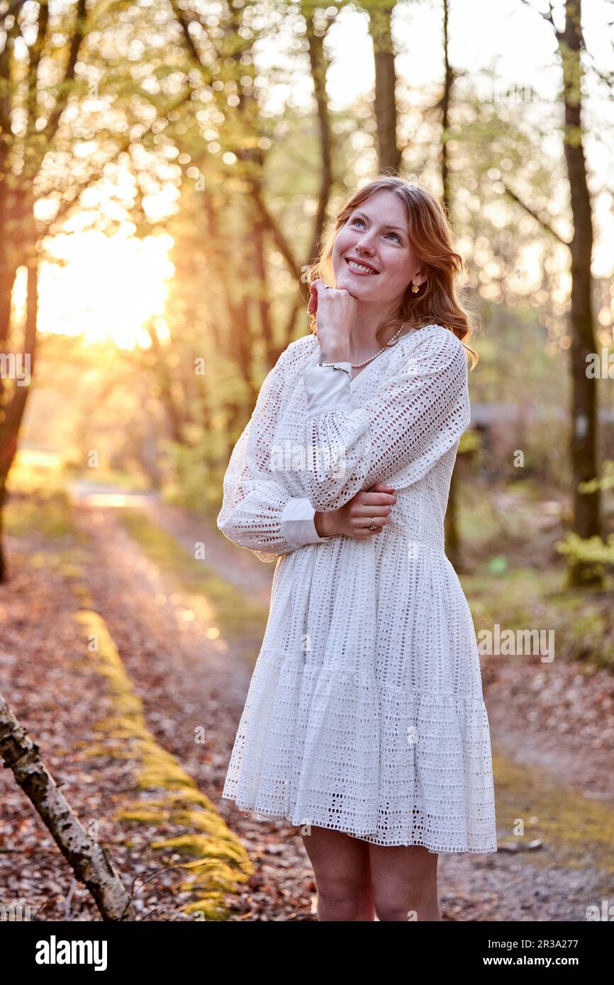 redhead girl in white dress in forest Stock Photo