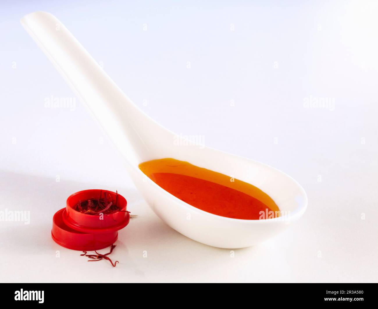 Homemade syrup with saffron, acacia honey and lime on a spoon Stock