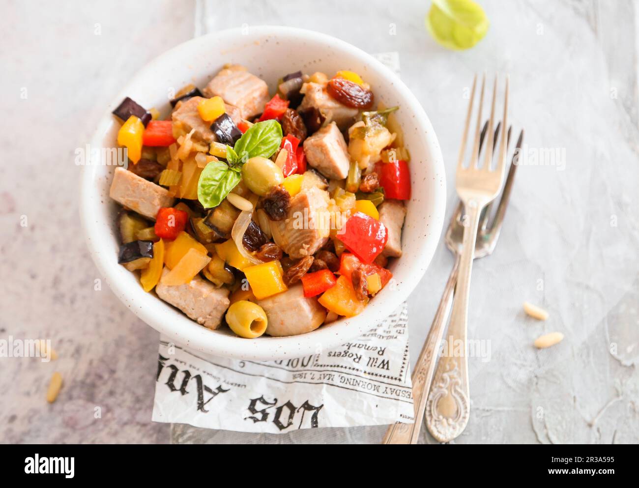 Eggplant caponata and peppers with olives raisins pine nuts and fresh swordfish Stock Photo