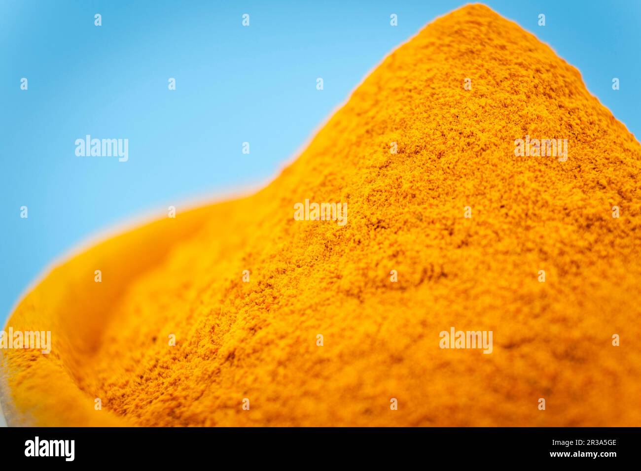 ground turmeric on blue background Stock Photo Alamy