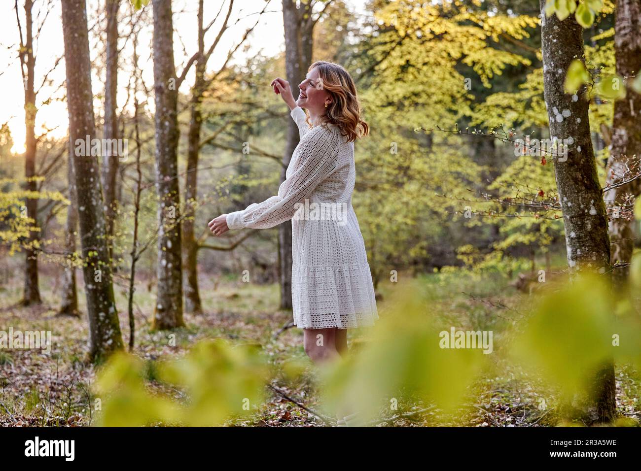 redhead girl in white dress in forest Stock Photo