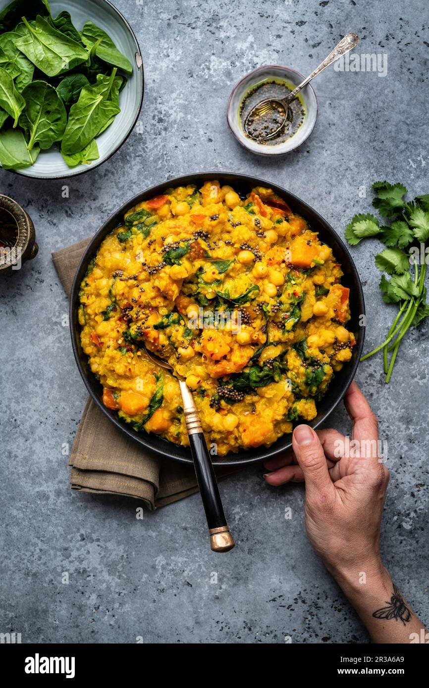 Vegan red lentil, chickpea and squash dahl with spinach in a bowl
