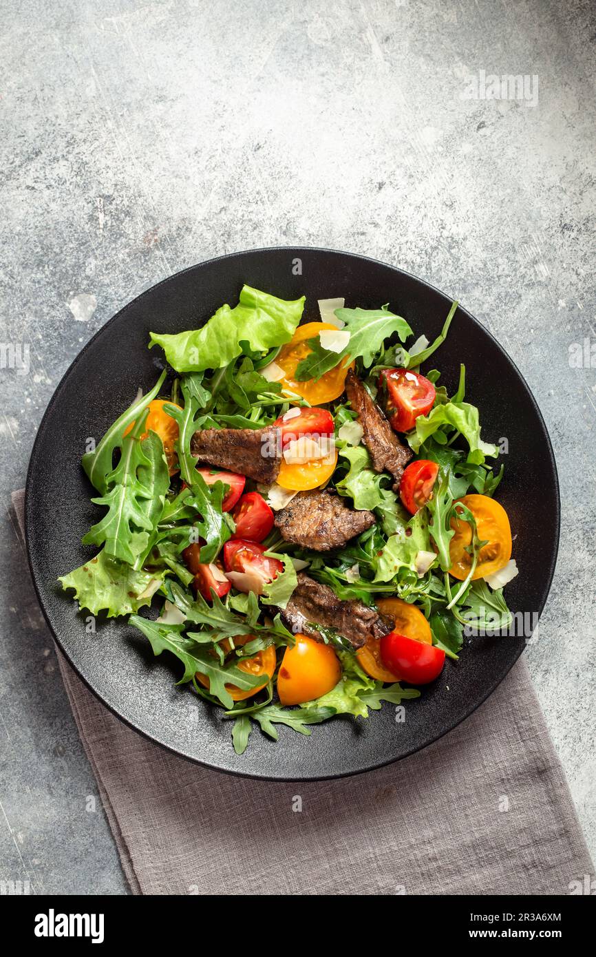 Arugula salad with seared beef cheese and tomatoes Stock Photo
