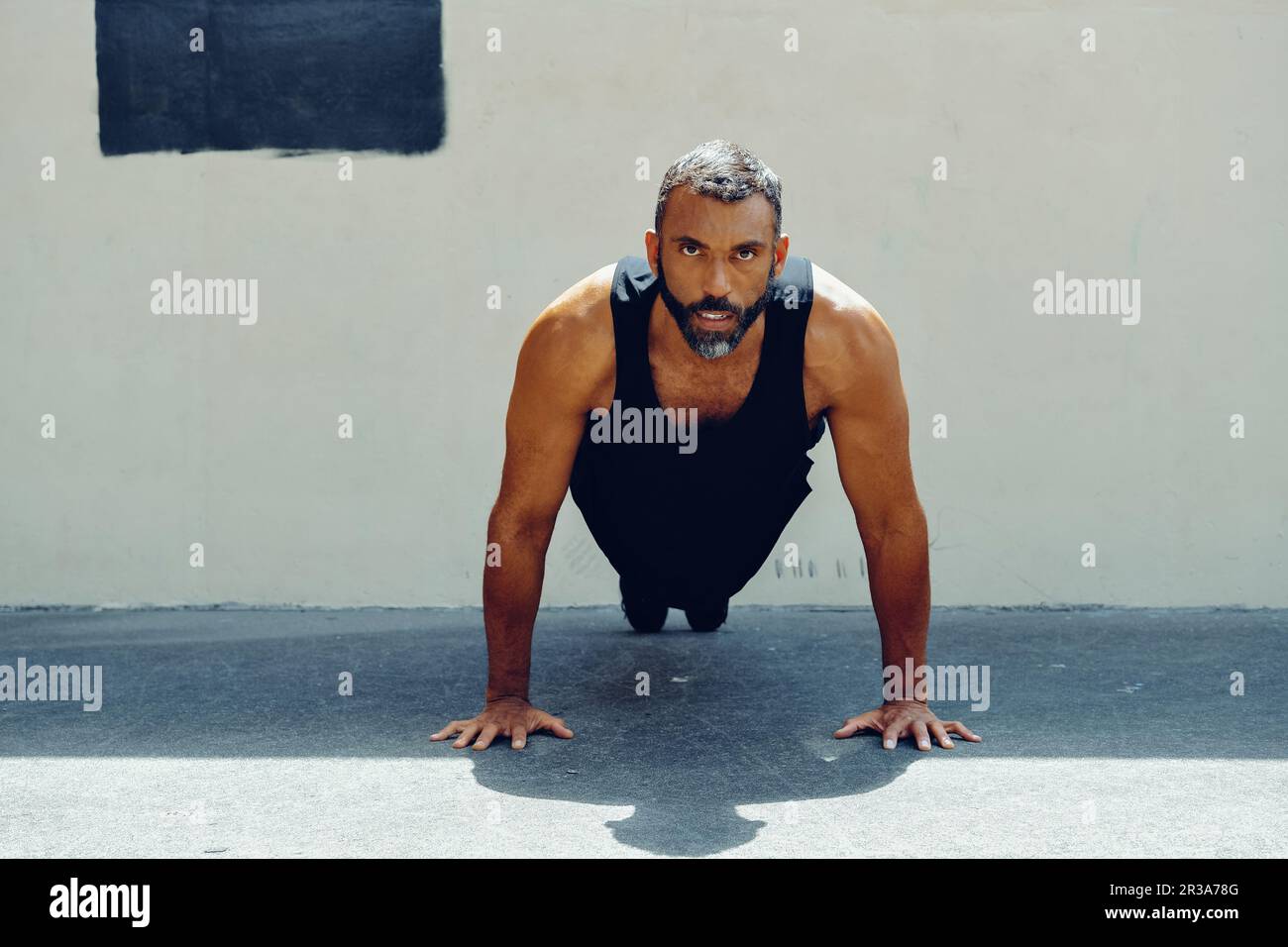 A fit athlete in sports clothing is performing a push up, demonstrating