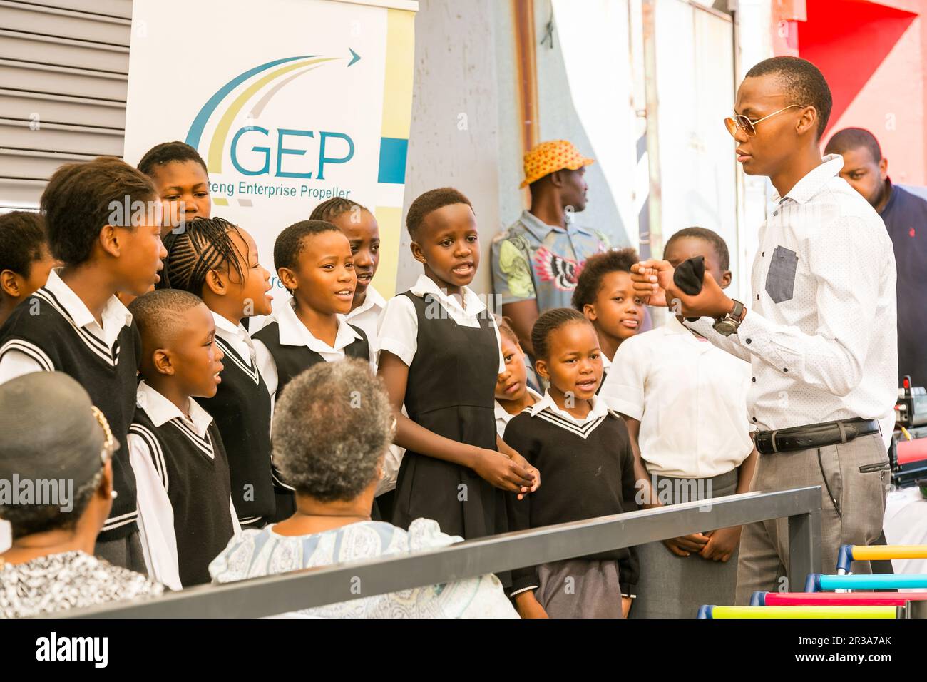 Young African Preschool kids singing songs outside local grocery shop Stock Photo