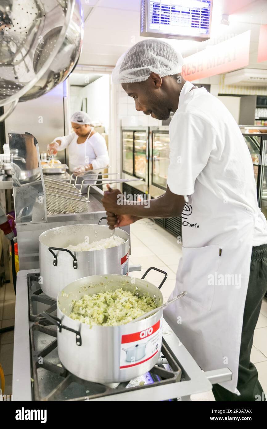 African male chef staff working in the kitchen of butchery and deli section at local Pick n Pay grocery store Stock Photo