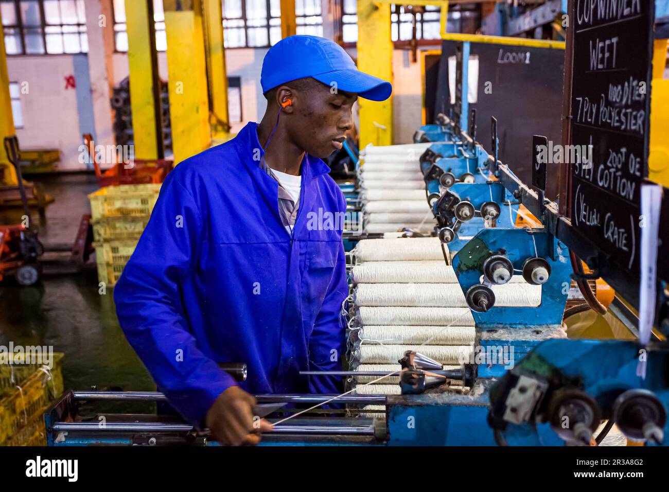 African factory worker on a copwinder weft assembly line loom Stock Photo