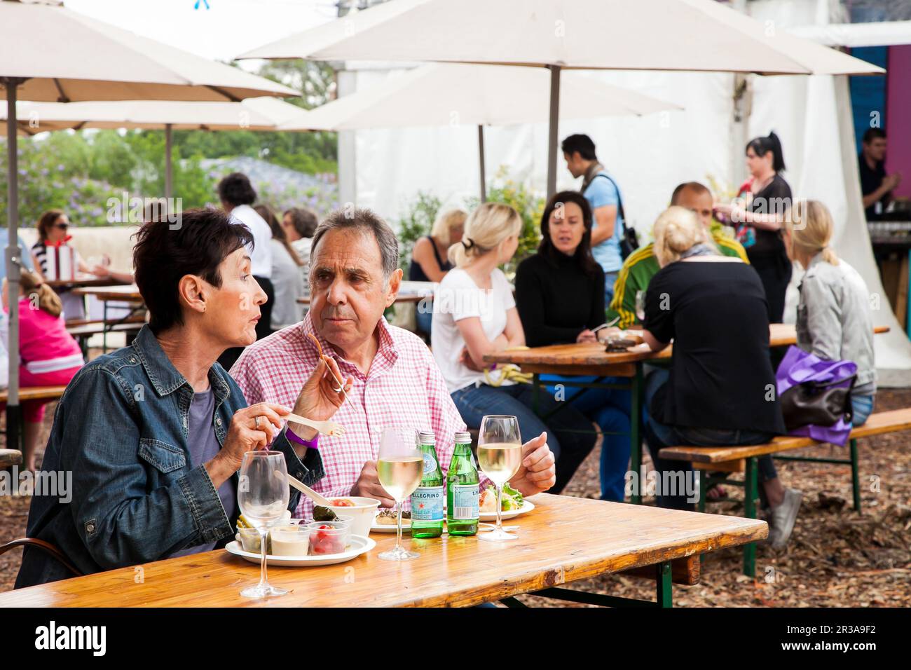 Middle aged couple eating, drinking and generally enjoying a day out at a Food and Wine Fair Stock Photo