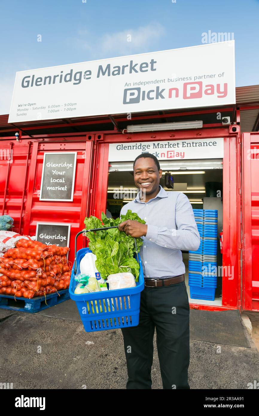 Owner manager standing outside Entrance at local Pick n Pay grocery store made out of shipping