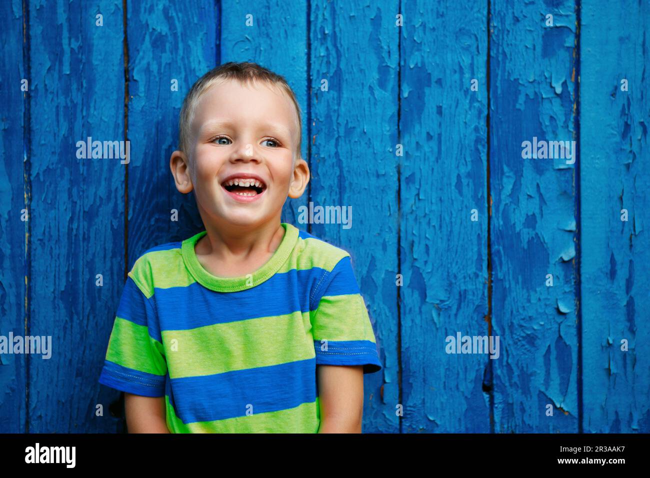 Portrait of happy joyful beautiful little boy against the old textured ...