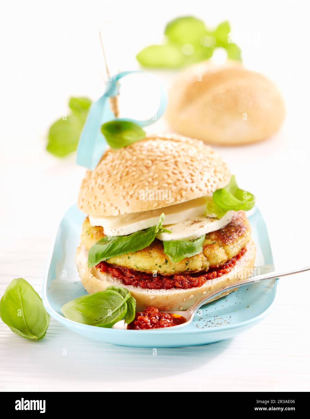 A vegetable burger with pesto rosso, mozzarella and basil Stock Photo