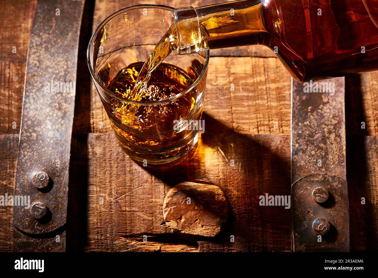 Bourbon pouring into rocks glass on a bourbon barrel Stock Photo