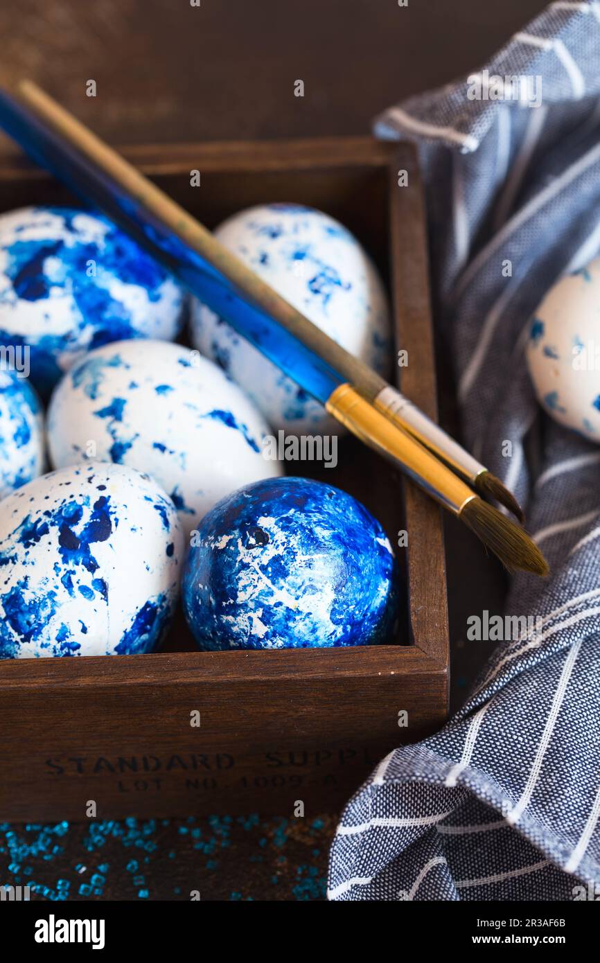 Dyed Easter eggs. Ð¡lassic blue 2020 Easter eggs on the brown background. Blue speckled easter eggs w Stock Photo