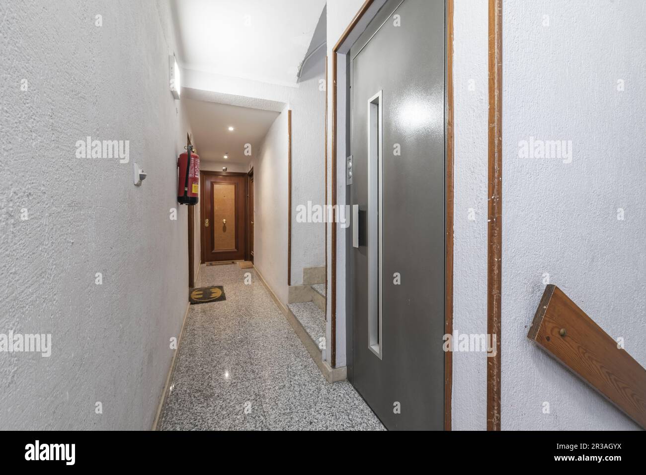 A narrow hallway on the landing of a residential building with a simple