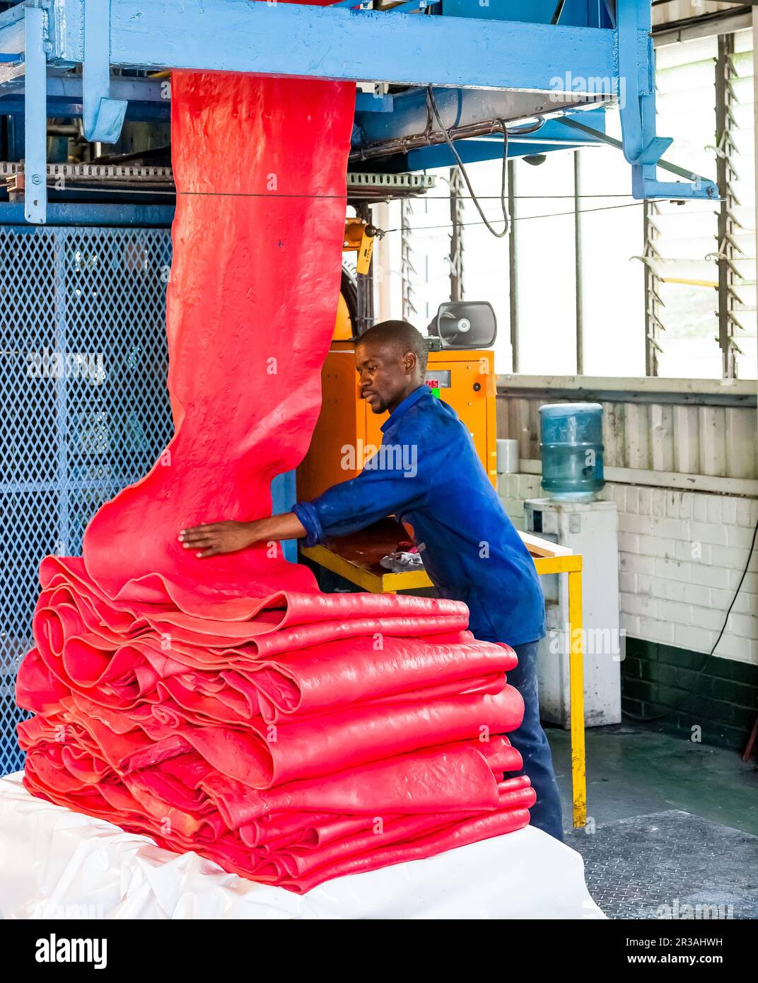 Diverse people working on an assembly line in a rubber factory Stock