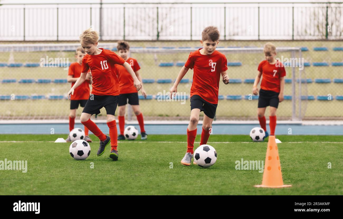 Young Boys at Soccer Training. Group of School Kids Kicking Soccer Balls During Practice Session. Children Improving Football Dribbling Skills Kicking Stock Photo