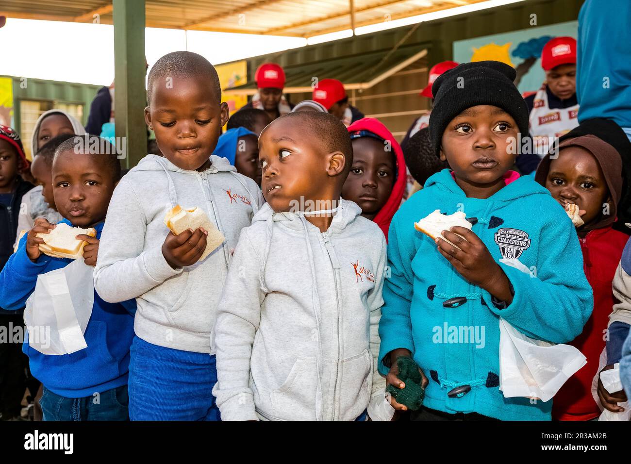 Young African Preschool kids eating sandwiches in the playground of a kindergarten school Stock Photo