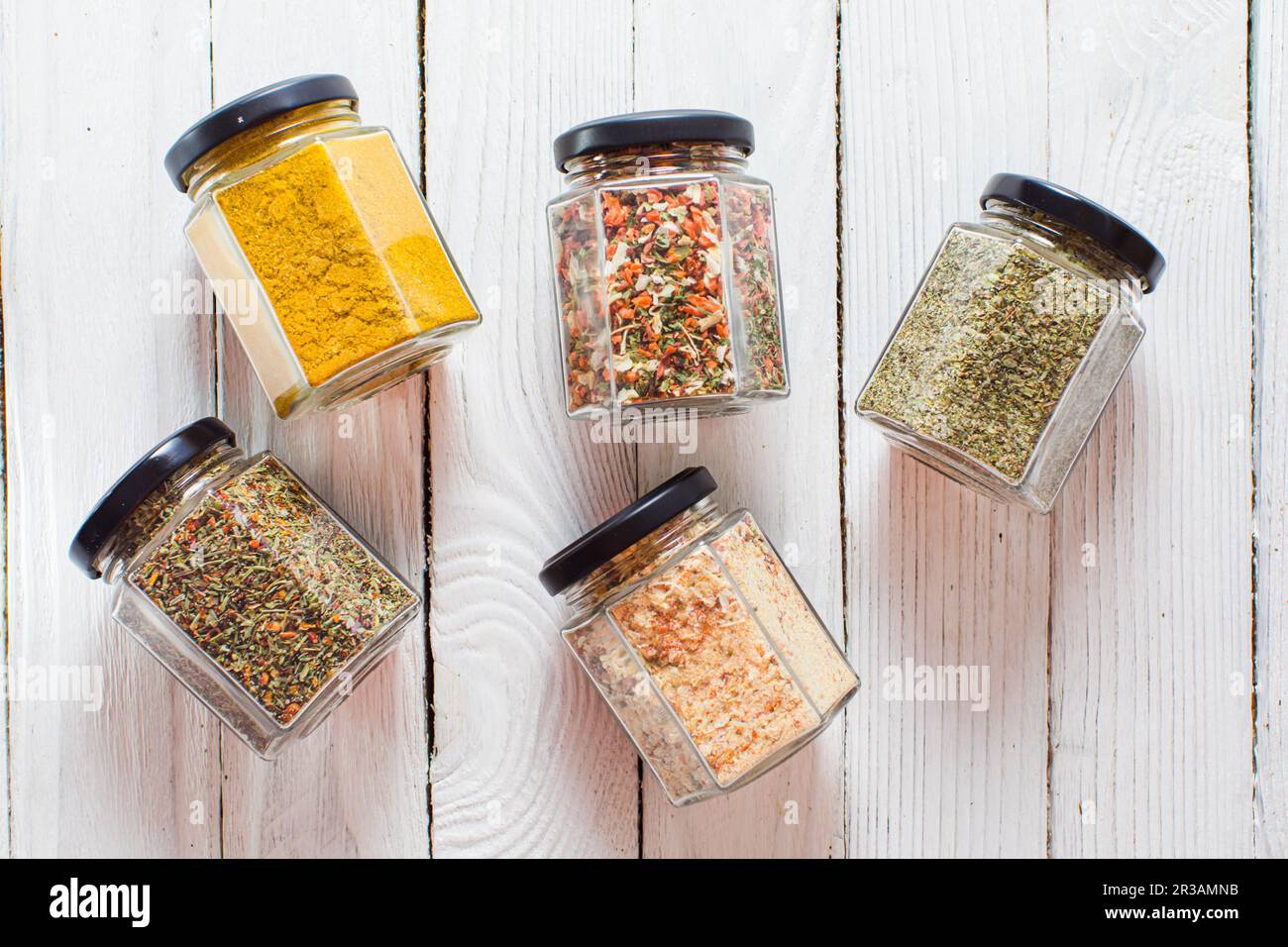 https://c8.alamy.com/comp/2R3AMNB/jars-with-various-spices-and-herbs-overhead-on-white-wooden-background-2R3AMNB.jpg