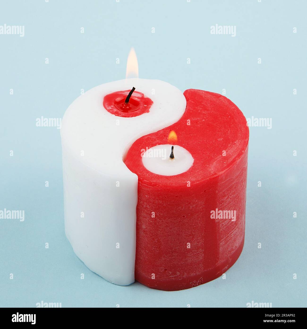 White and red Yin Yang handmade candle on blue background. Double