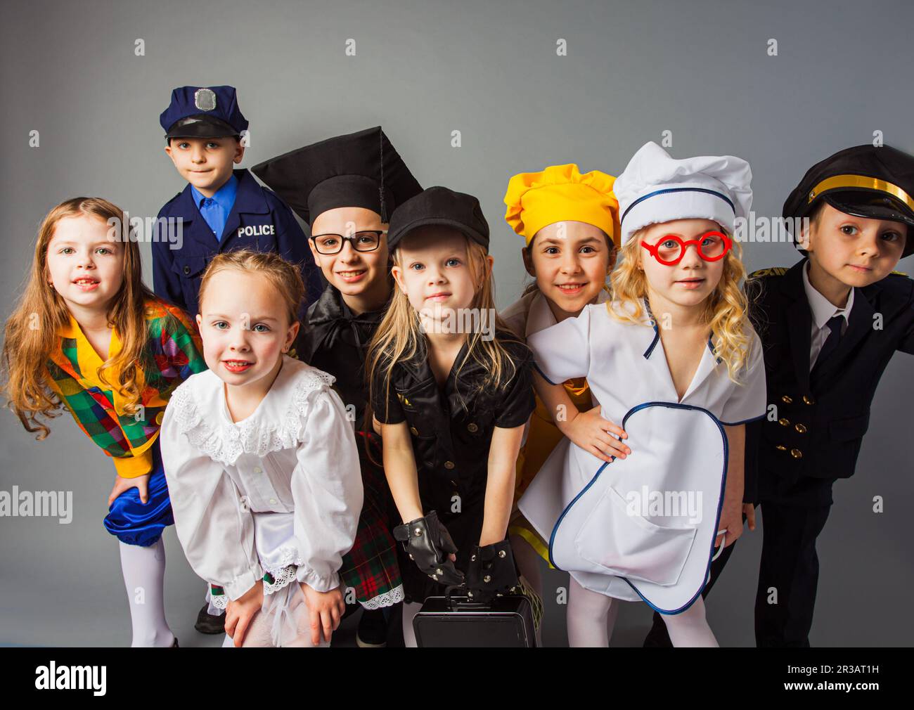 The group of different little children dressed in uniforms of different